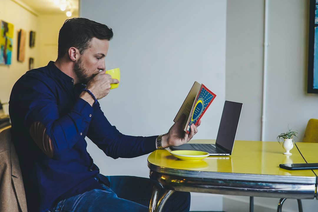 Person sitting quietly at a window with a cup of tea, calm and thoughtful, morning light