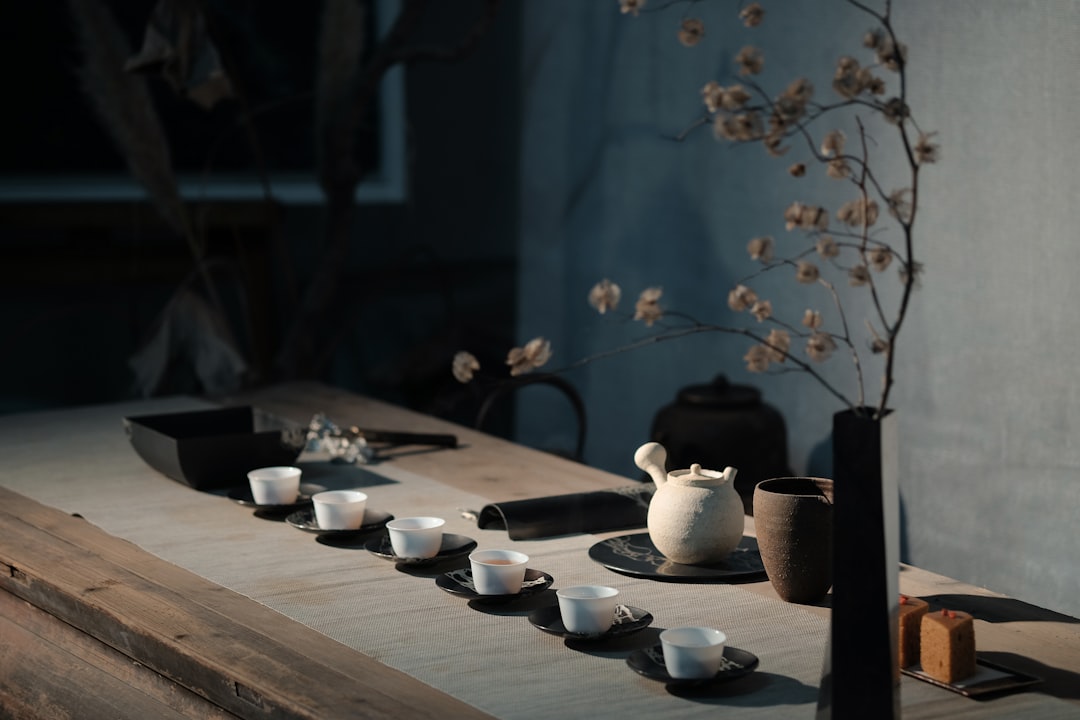 Person sitting quietly by a dim lamp in the evening, hands wrapped around a warm mug, winding down before bed