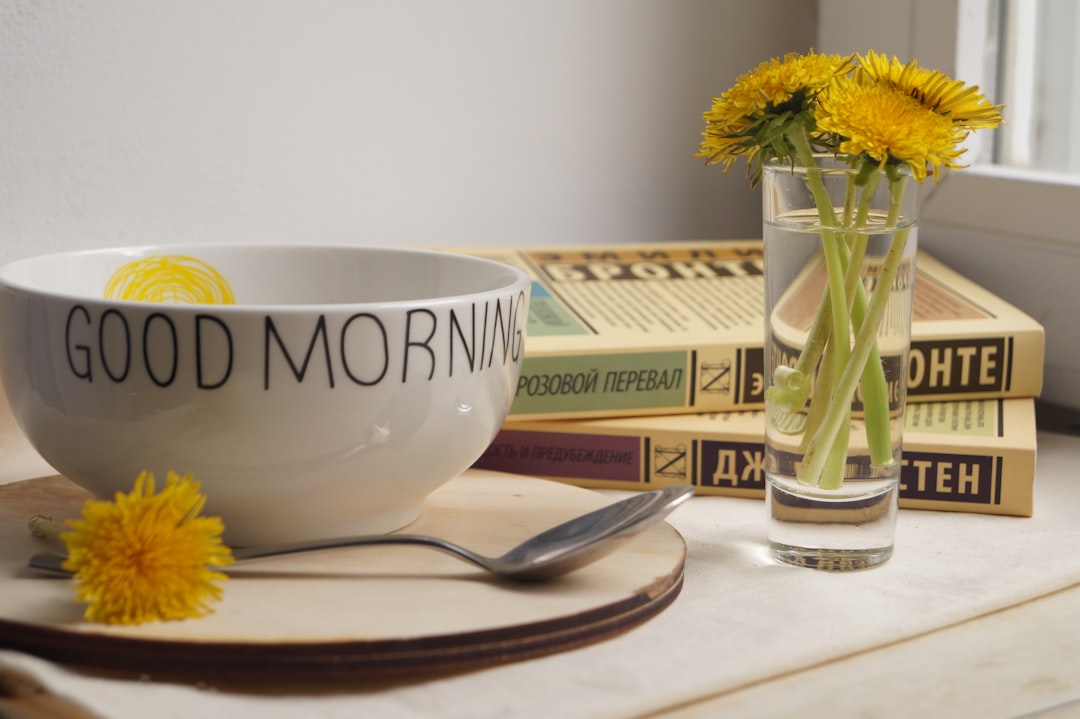 Person holding a warm mug by a sunlit window in the early morning, a calm and unhurried start to the day.