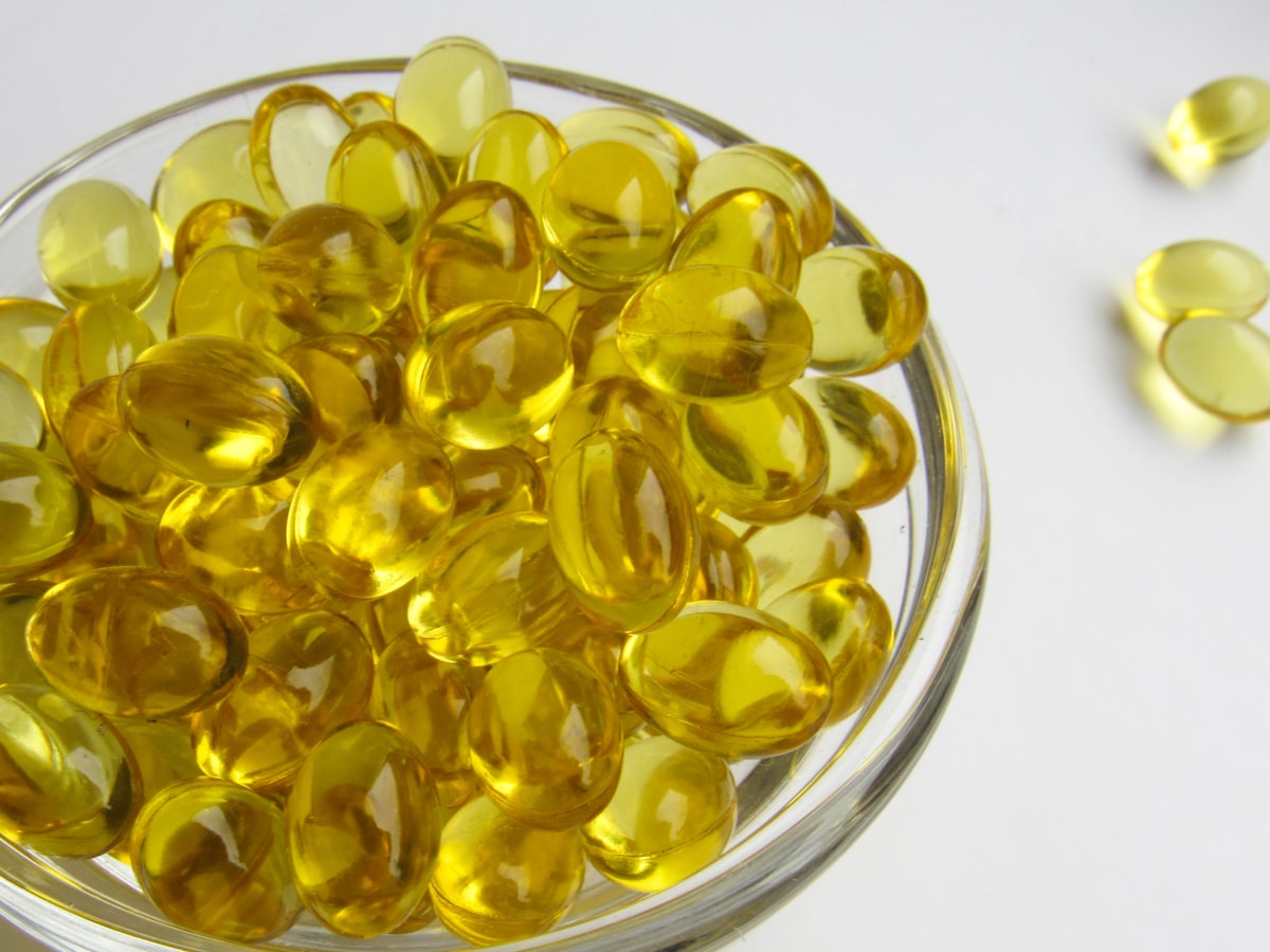 Side-by-side view of ETC hemp softgel capsules and fruit gummies on a clean white surface in natural light