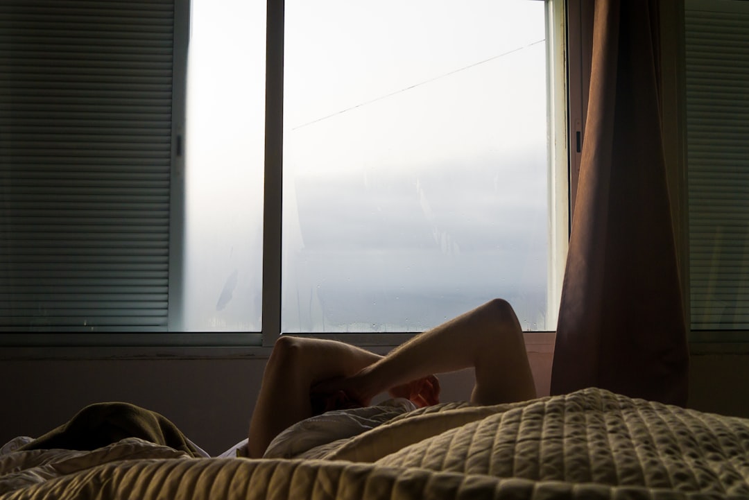 Person sitting in soft lamplight with a warm drink and a small supplement, quietly unwinding at the end of the day